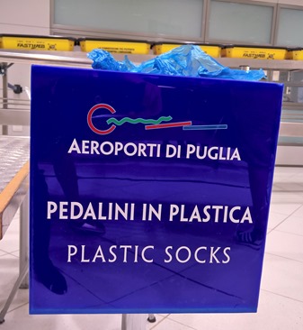 contenitore con la scritta AEROPORTI DI PUGLIA - PEDALINI IN PLASTICA - PLASTIC SOCKS
