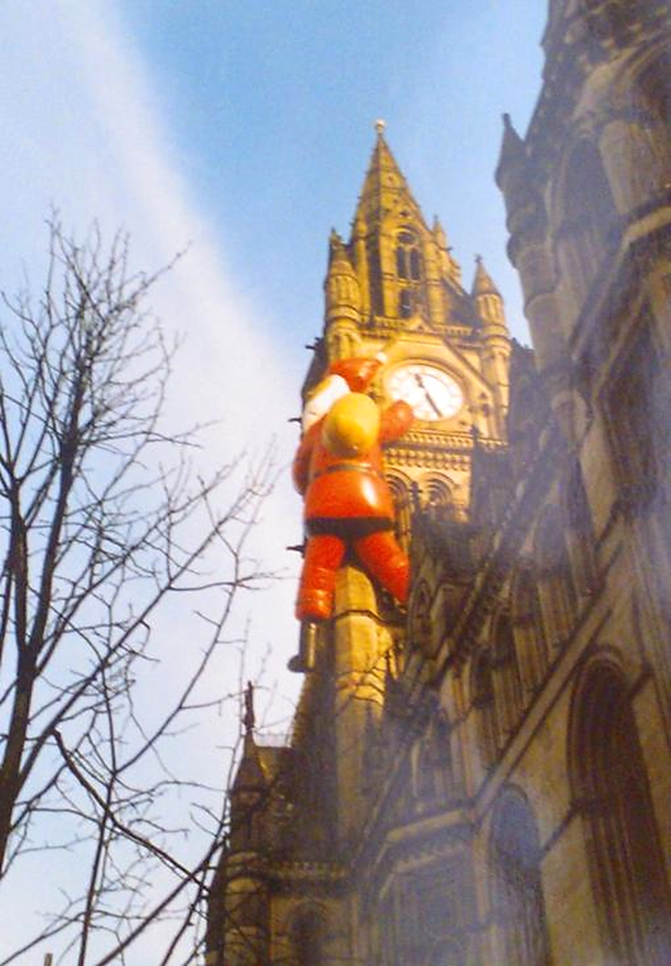 foto di Babbo Natale appeso alla Clock Tower del Manchester Town Hall